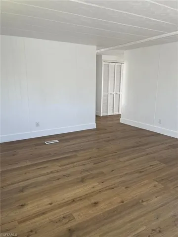 Spare room featuring dark wood-type flooring