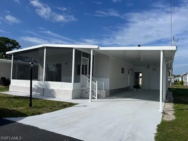 View of property exterior with a carport and a sunroom