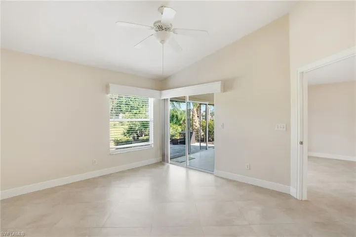 Unfurnished room featuring lofted ceiling, a ceiling fan, and light tile patterned flooring