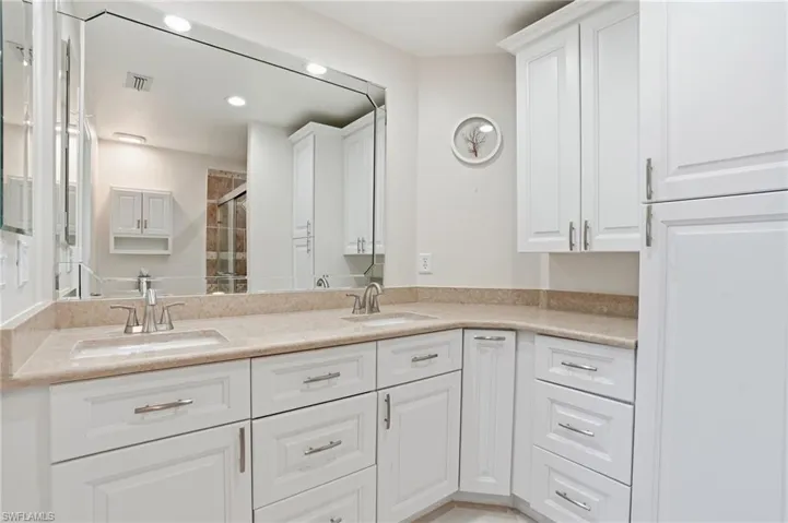 Full bath featuring double vanity, a shower stall, and recessed lighting