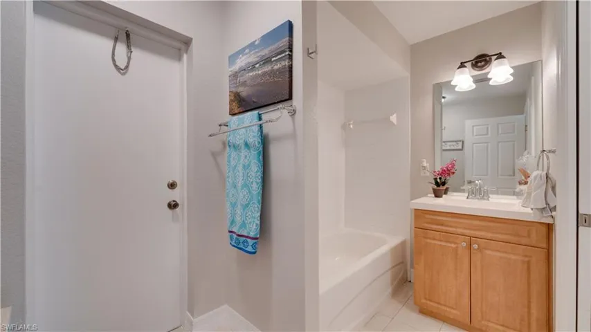 Pool bath - full bathroom featuring vanity, light tile patterned floors, and tub / shower combination
