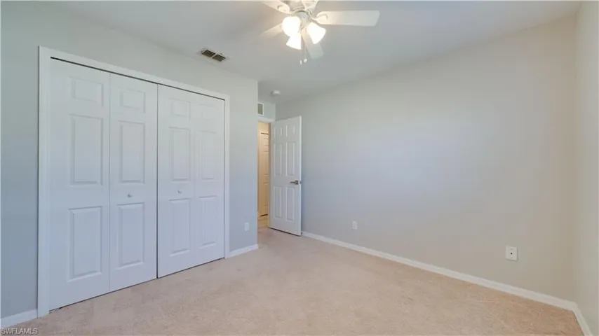 Unfurnished bedroom featuring carpet flooring, a ceiling fan, and a closet