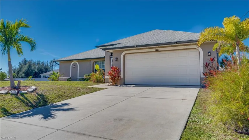 Single story home featuring stucco siding, a front lawn, driveway, and a shingled roof