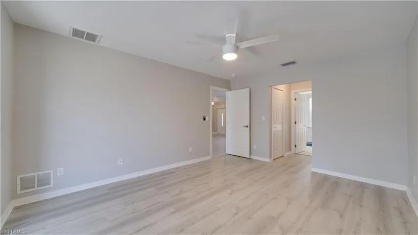 Unfurnished bedroom featuring light wood-style floors, a closet, and ceiling fan
