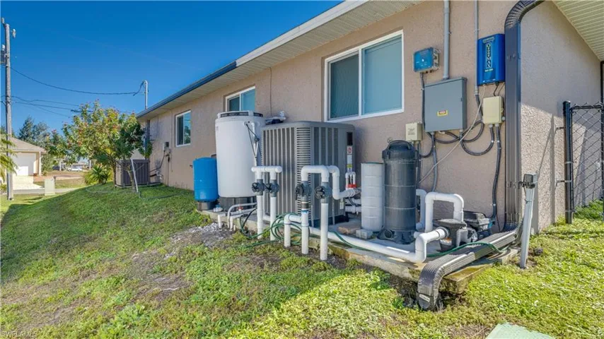 Exterior view of stucco siding and a water treatment tank