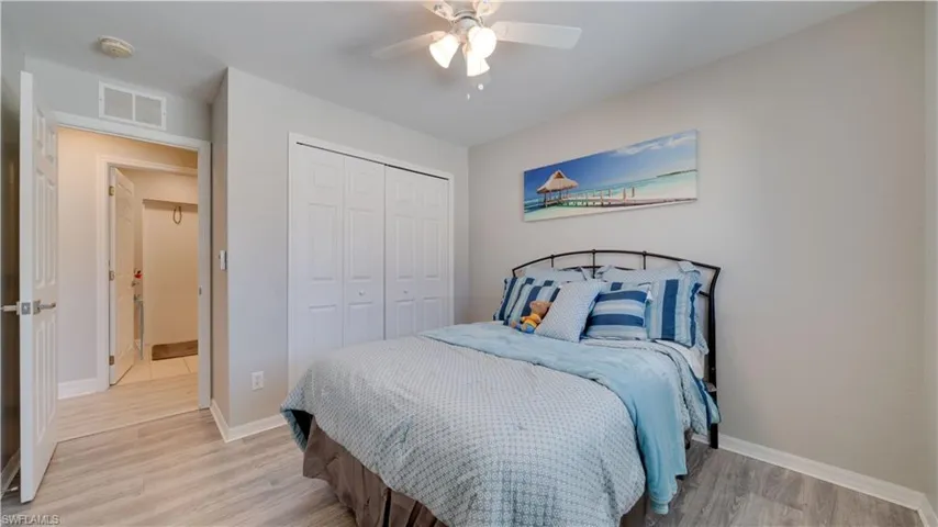 Bedroom with light wood-style flooring, a closet, and ceiling fan