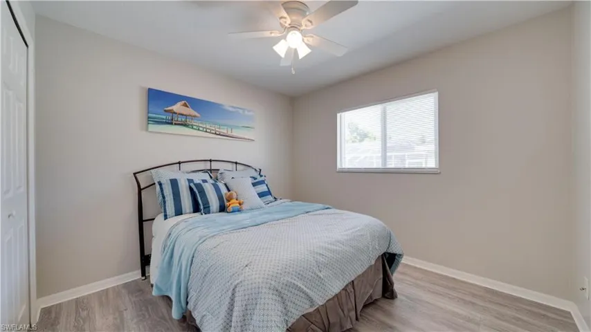 Bedroom with a closet, light wood-style floors, and ceiling fan