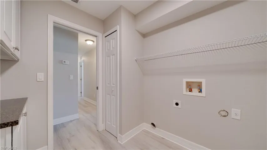 Laundry area featuring electric dryer hookup, hookup for a washing machine, light wood-style floors