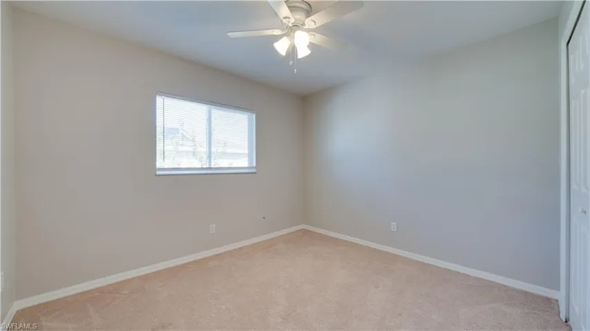 Unfurnished room with light colored carpet and ceiling fan