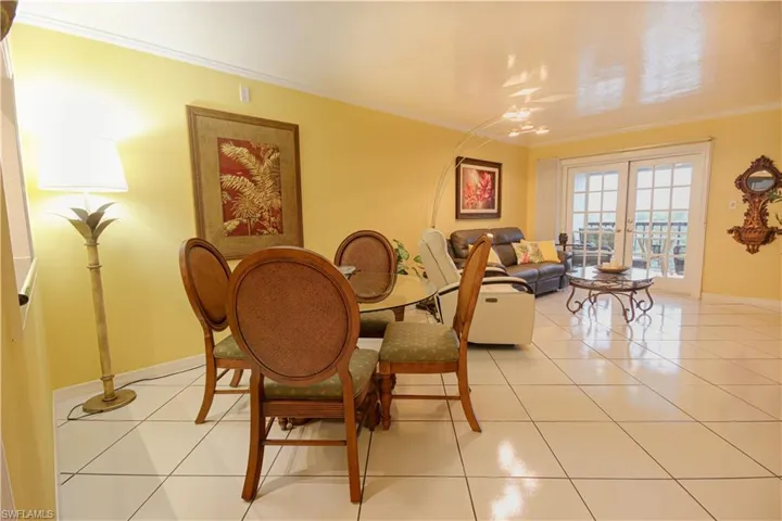 Dining room with ornamental molding, french doors, and light tile patterned flooring