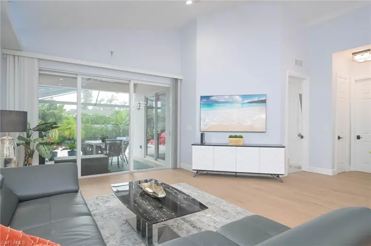Living room featuring high vaulted ceiling and light wood-type flooring