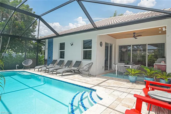 View of pool with an outdoor shower, lanai, a patio area, and ceiling fan. Plenty of room for entertaining!