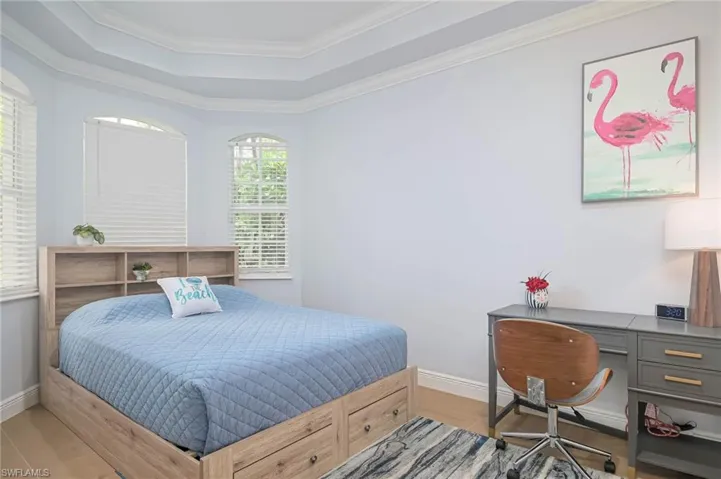 Bedroom 2 featuring crown molding, light  flooring, and a raised ceiling