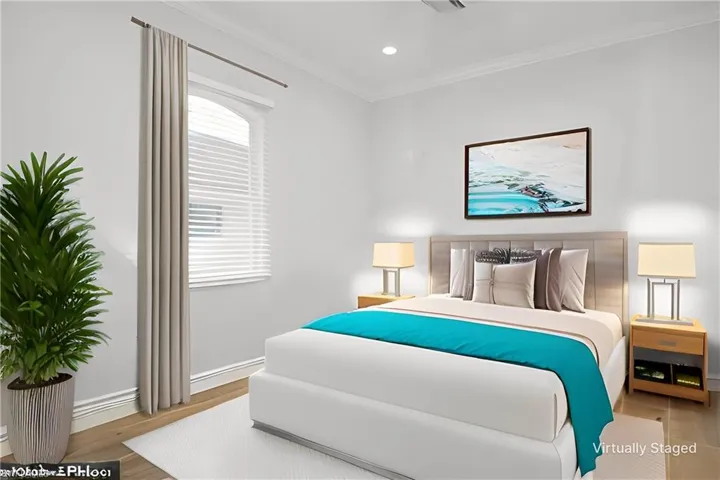 Virtually Staged Bedroom with crown molding and light wood-type flooring
