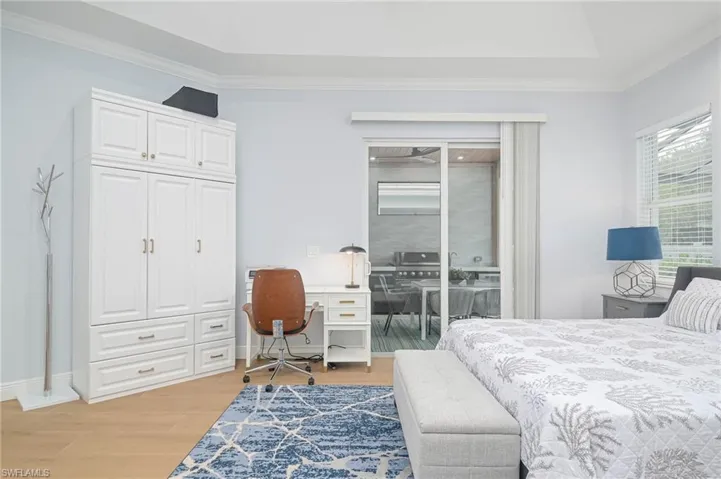 Primary Bedroom with crown molding, light hardwood / wood-style floors, and access to outside