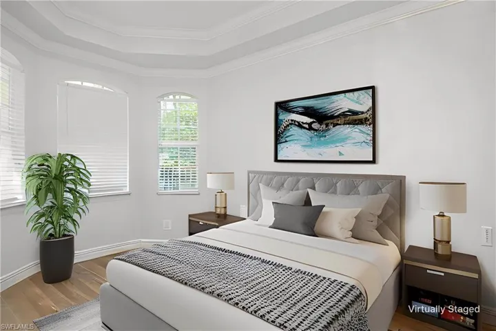 Virtually Staged Bedroom with a raised ceiling, hardwood / wood-style floors, and ornamental molding