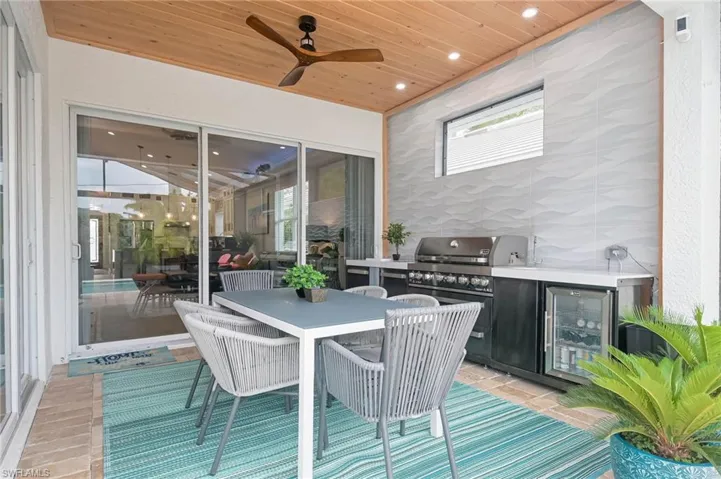 Lanai with custom kitchen and seating area with ceiling fan