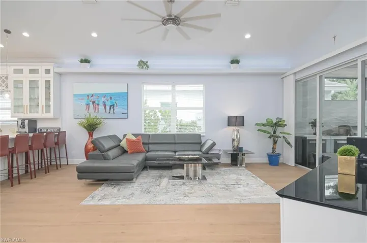 Living room with ceiling fan and light hardwood / wood-style floors