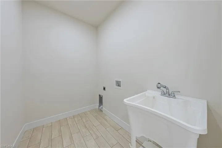 Laundry room with hookup for a washing machine, light wood-style floors, and electric dryer hookup