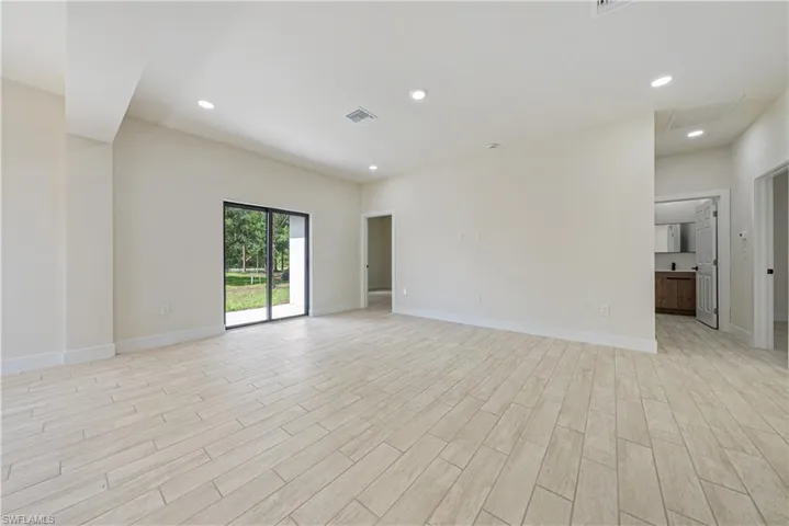 Living room with light wood finished floors and recessed lighting