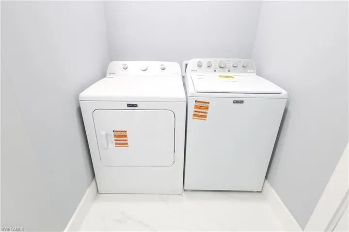 Laundry room with washer and dryer and light marble finish floors