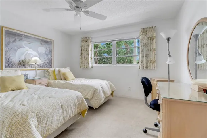 Bedroom featuring light carpet, ceiling fan, and a textured ceiling