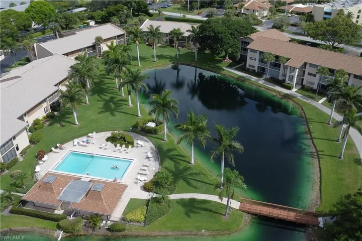 Aerial view of property and surrounding area with a large body of water and a pool area
