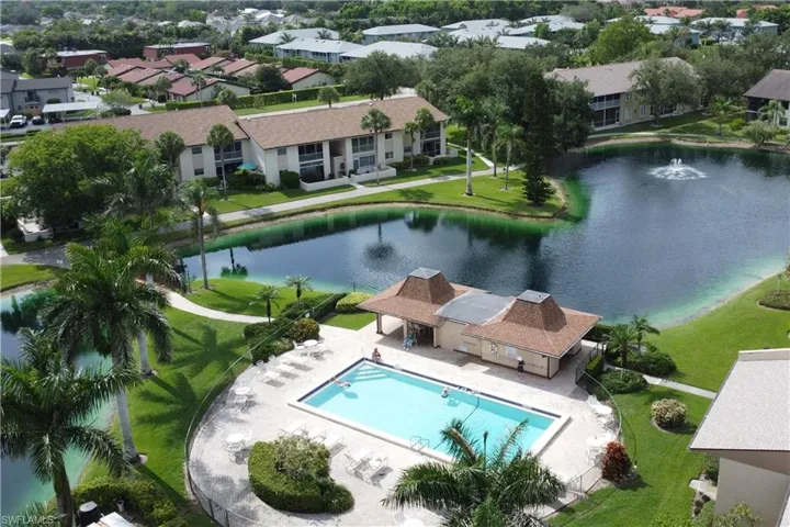 Aerial view of residential area with a pool and a nearby body of water