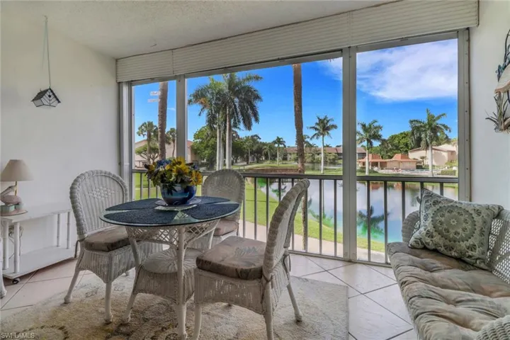 Sunroom / solarium with a water view and tile patterned flooring
