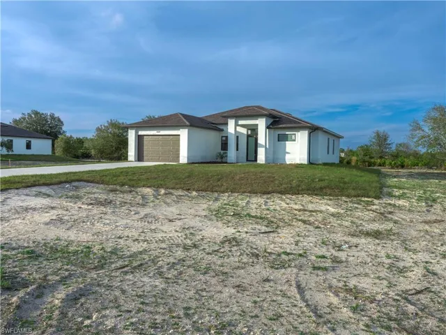 View of front of property featuring a front yard and a garage