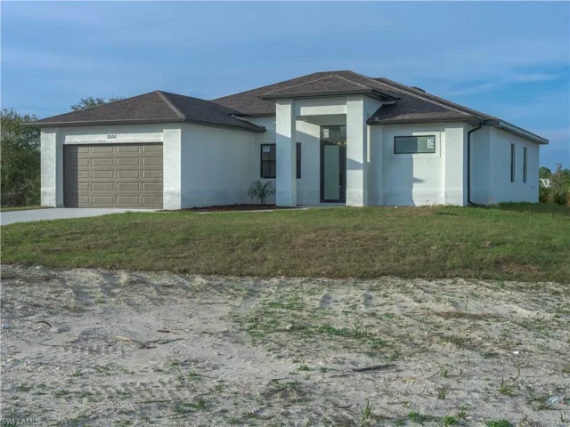 Prairie-style house featuring a garage and a front yard