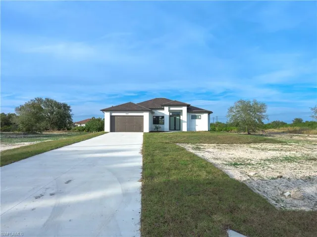View of front of house featuring a front lawn and a garage