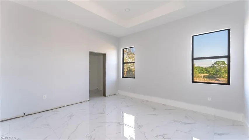 Unfurnished room with a raised ceiling