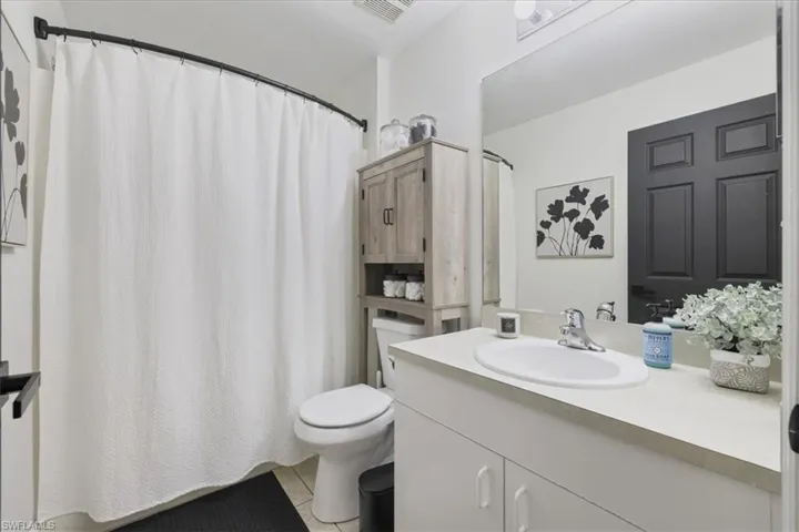 Full bath featuring tile patterned floors, vanity, and a shower with curtain