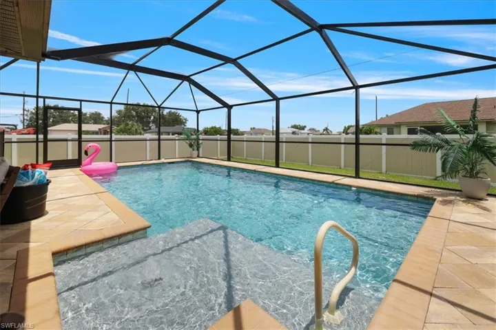 View of swimming pool with a patio area and glass enclosure