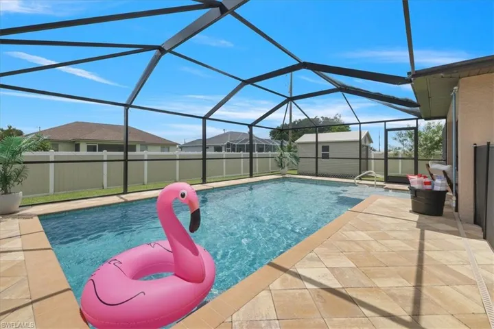 View of pool with a storage unit, a patio area, a fenced backyard, and a lanai
