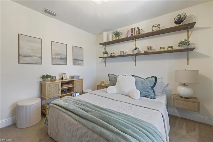 Bedroom featuring carpet and baseboards