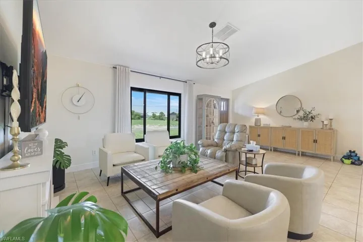 Living area with light tile patterned floors and a chandelier
