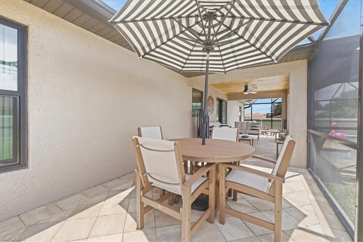 Sunroom / solarium with outdoor dining space and ceiling fan