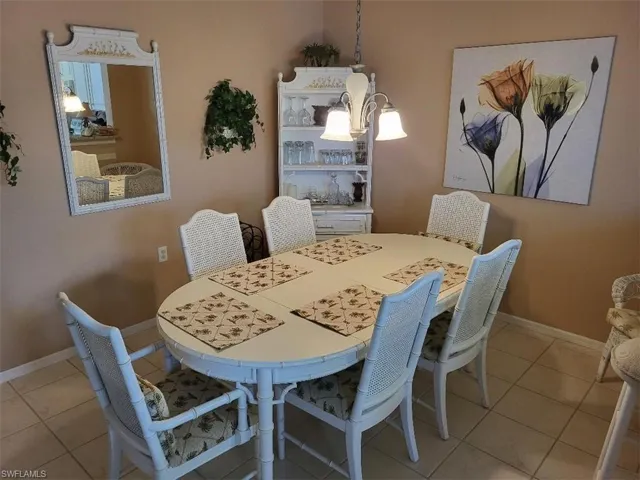 Dining Area with Light Tile Patterned Floors and a Chandelier