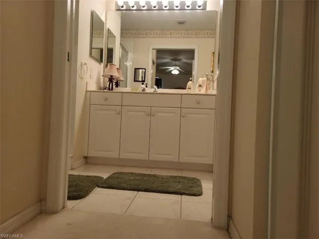 Bathroom with vanity, light tile patterned floors, and a ceiling fan