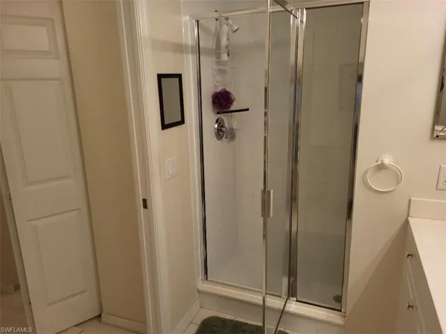 Master Bathroom with Vanity, a Shower and Light Tile Patterned Flooring
