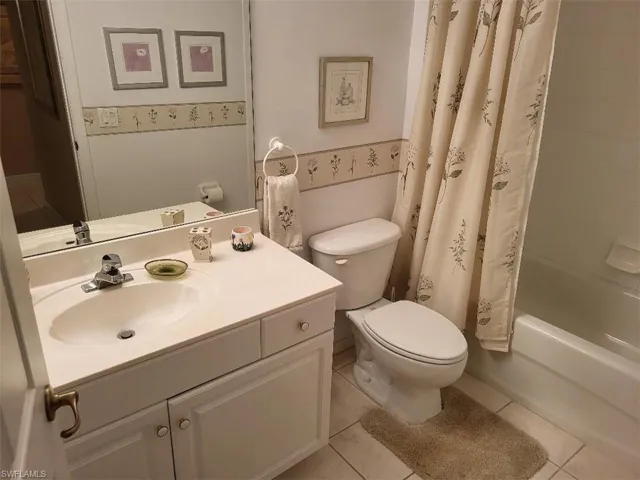 Guest Bath Featuring Vanity, Light Tile Patterned Floors and Shower/Tub Combo