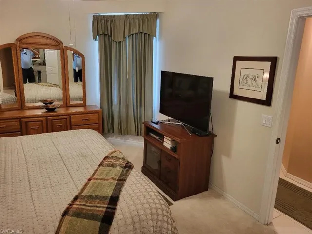 Bedroom featuring light carpet and baseboards