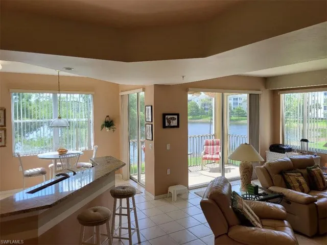Living room featuring light tile patterned flooring and a water view
