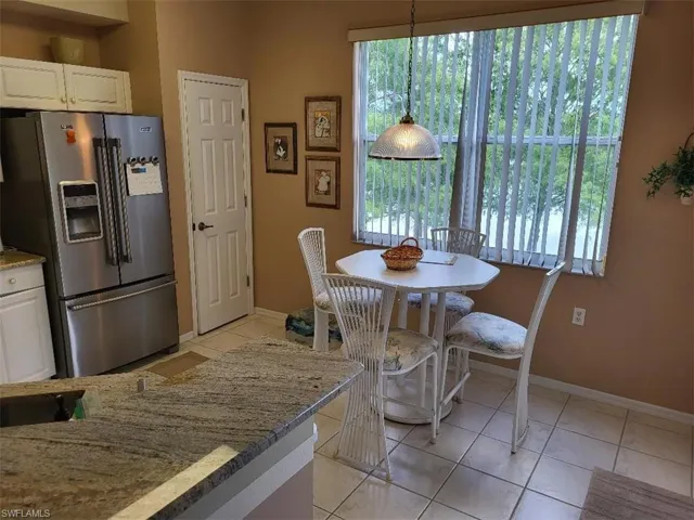 Kitchen Nook with Stainless Steel Refrigerator and Granite Countertops