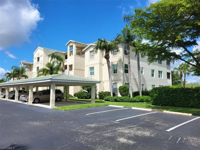 View of building exterior featuring uncovered parking