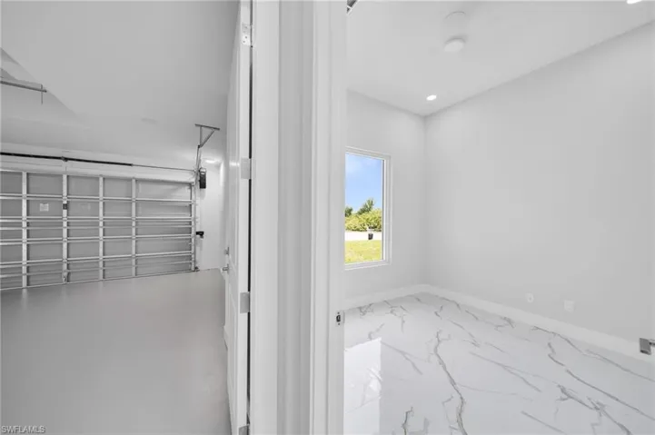 Bathroom with marble look tile flooring, baseboards, and recessed lighting