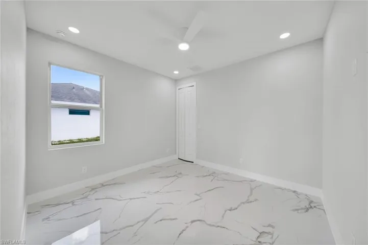 Unfurnished room with recessed lighting, light marble finish flooring, ceiling fan, and baseboards