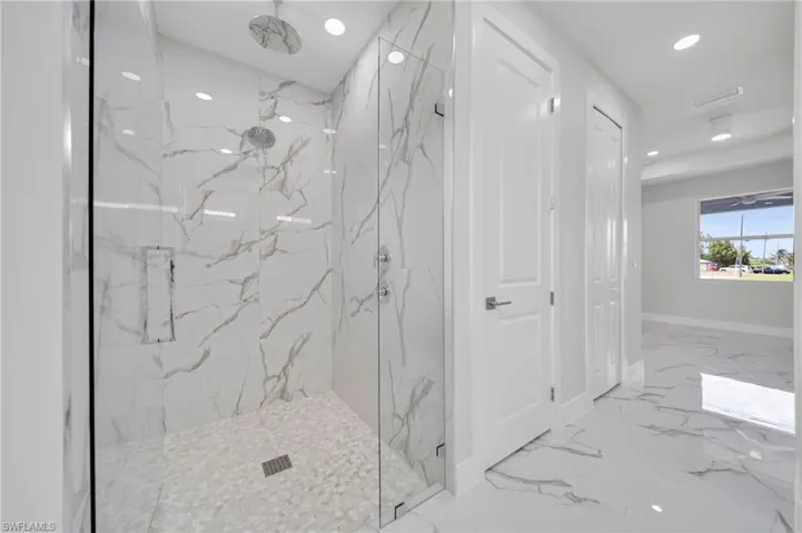 Bathroom with marble tiled floors, a marble finish shower, recessed lighting, and baseboards